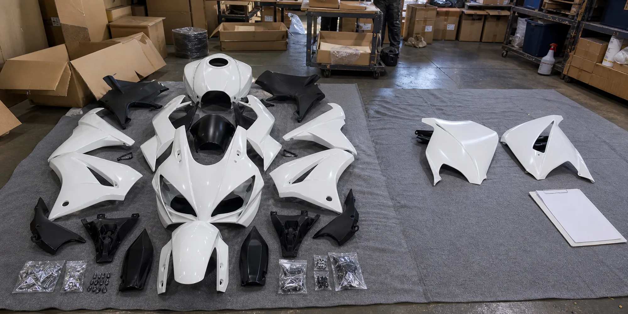Complete aftermarket motorcycle fairing kit laid out beside sparse replacement panels